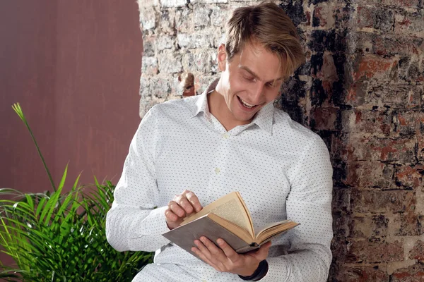 Um jovem de camisa branca a ler um livro. Literatura de negócios para auto-desenvolvimento . — Fotografia de Stock