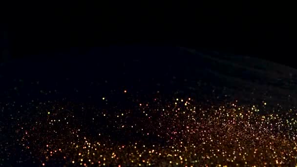 Bouncing gold particles on a black background, the concept of rhythm or music — 图库视频影像