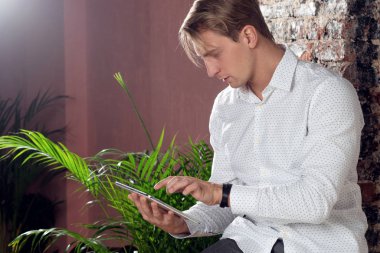 Beyaz gömlekli genç adam iş ve iş için dijital tablet kullanıyor..