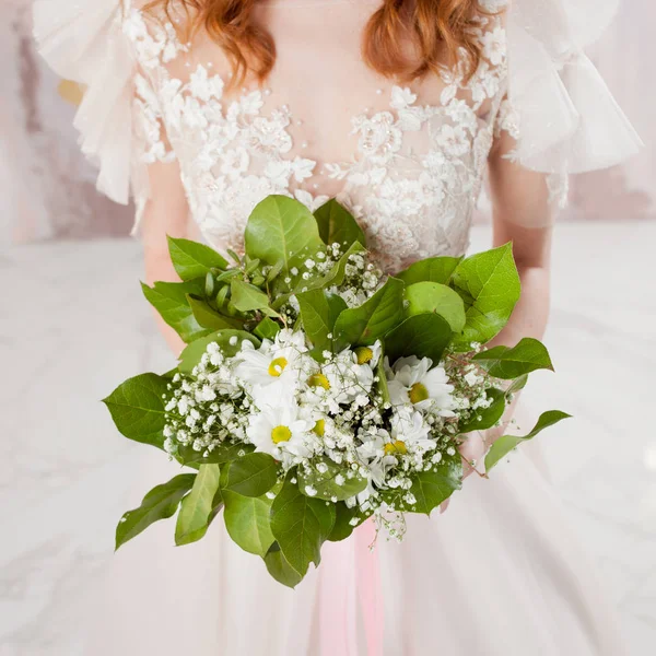 Weelderige bruiloft boeket in de handen van de bruid. Een meisje in een trouwjurk met een boeket — Stockfoto