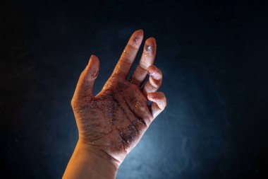 Pullarla kaplı bir kadın eli. Avuç içi hareketlerin ve çok renkli parıltıların,