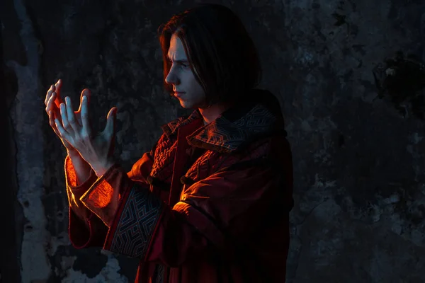 Concept of the history of science. A young man in the image of a medieval scientist holding something in his hand, — Stok fotoğraf