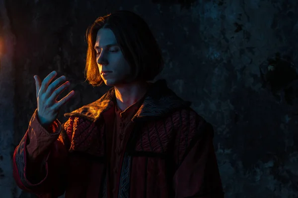 Concept of the history of science. A young man in the image of a medieval scientist holding something in his hand, — Stock Photo, Image