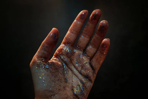 Mano femminile ricoperta di paillettes. Il movimento del palmo della mano e brillare glitter multicolore , — Foto Stock