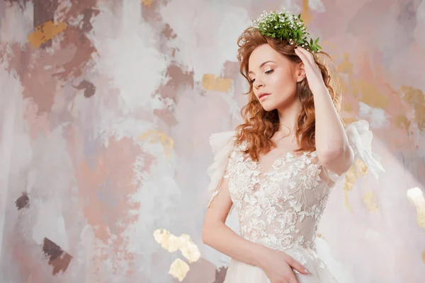 Portrait of a young beautiful woman in wedding dress with wreath of fresh flowers. — Stock Photo, Image