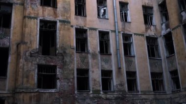 Terk edilmiş ve yanmış bir binanın ön cephesi, bombalamadan sonra çıkan bir yangın.