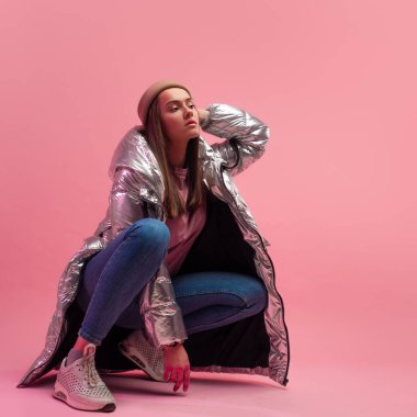 Kabarık ceketli şık ve modern genç bir bayan. Ceket gümüş metalik bir renktir..