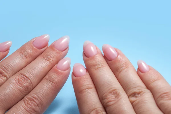 Mani da donna con manicure Nuda perfetta. Smalto per unghie è una tonalità naturale rosa pallido . — Foto Stock