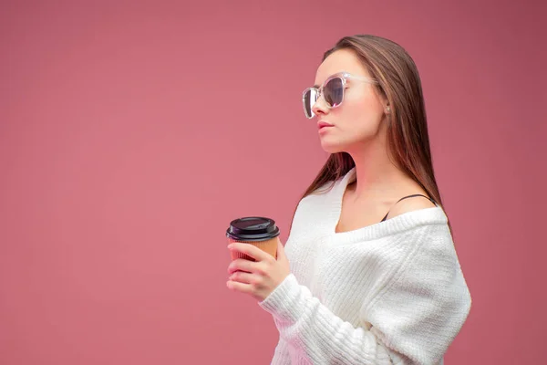 Mujer joven de negocios con ropa informal, sosteniendo una taza de cartón con una bebida caliente en la mano . — Foto de Stock