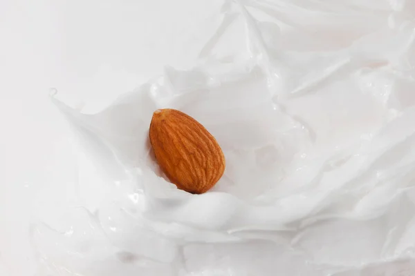 Du lait d'amande. Beaucoup d'amandes et d'éclaboussures de lait . — Photo