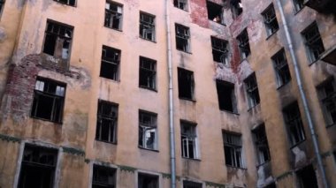 Terk edilmiş ve yanmış bir binanın ön cephesi, bombalamadan sonra çıkan bir yangın.