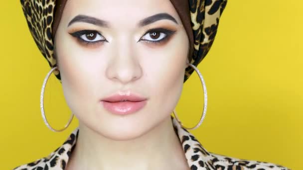 Mujer joven valiente y hermosa en un turbante con un estampado de leopardo , — Vídeos de Stock