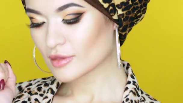 Mujer joven valiente y hermosa en un turbante con un estampado de leopardo , — Vídeos de Stock