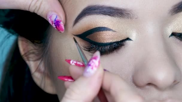 Salón de belleza, artista de maquillaje hace maquillaje de noche. Hermosos ojos con sombra de ojos dorada . — Vídeos de Stock