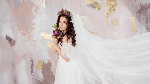 Mooie jonge bruid in trouwjurk met sluier op haar gezicht — Stockfoto