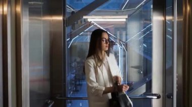 Young business lady in the Elevator in the business center, the doors are closing.