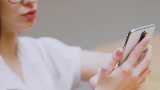 Jeune fille brune utilise un smartphone pour communiquer. Communication en ligne dans les messagers , — Video
