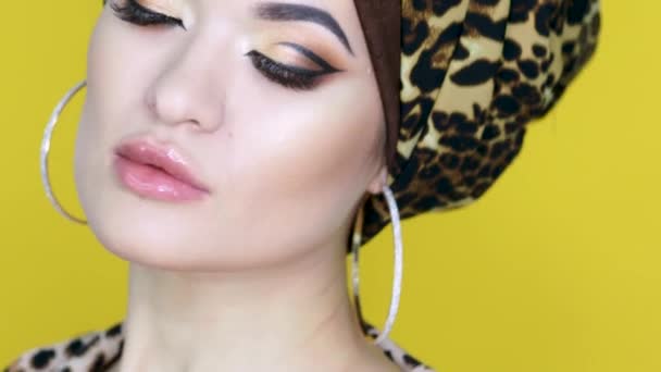 Jovem corajosa e bonita em um turbante com uma impressão de leopardo , — Vídeo de Stock
