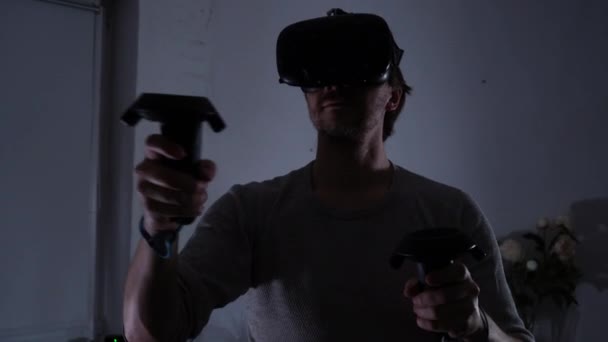 Jovem geek masculino está jogando um jogo de realidade virtual em casa. Um quarto escuro , — Vídeo de Stock