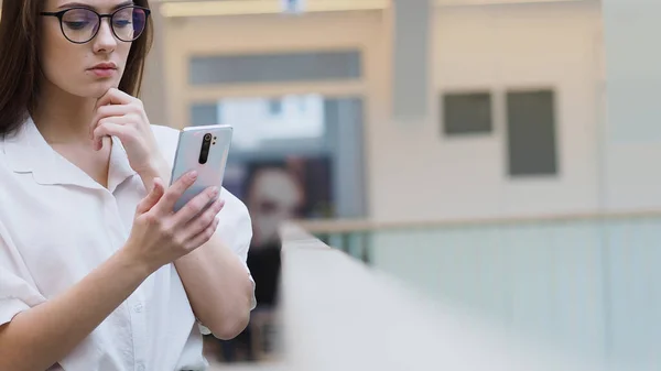 Jovem mulher em roupas de negócios elegantes usa um smartphone , — Fotografia de Stock