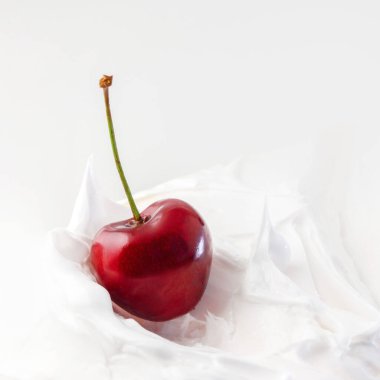 Tatlı kiraz yoğurt içinde. Kiraz ile yakın çekim süt ya da peynir tatlısı.