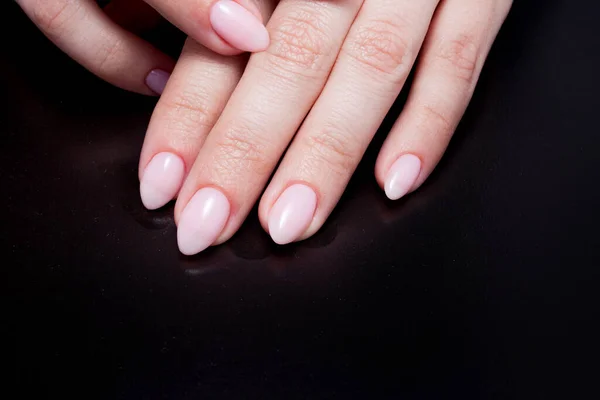 Mãos de mulher com manicure Nude perfeito. Unha polonês é uma sombra rosa pálida natural . — Fotografia de Stock
