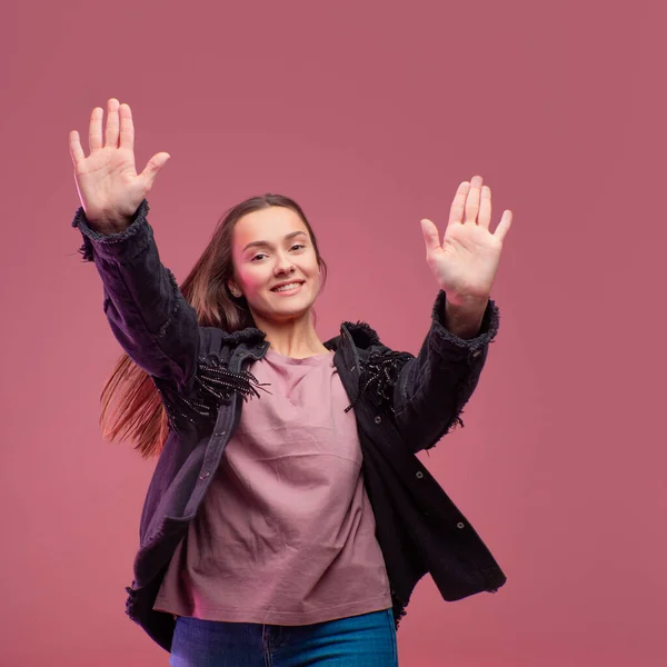 Joven morena mujer hace un saludo informal, fondo rosa. Retrato de estudio , — Foto de Stock