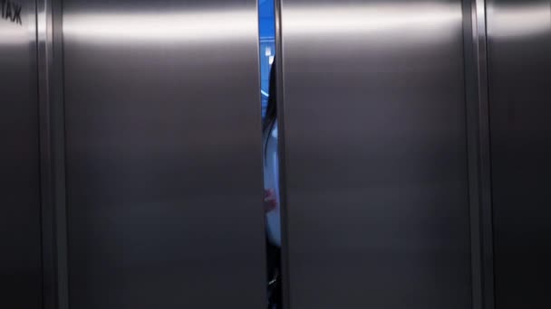 Молода бізнес-леді в ліфті в діловому центрі, неформальне привітання колег . — стокове відео