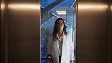 İş merkezindeki asansördeki çekici genç iş kadını. Genç bir kadın.