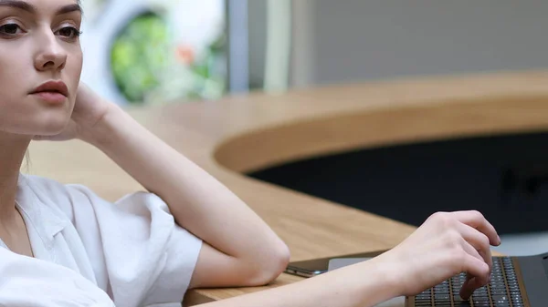 Freelancing y trabajo remoto. Mujer joven con gafas escribiendo una carta en un ordenador portátil , —  Fotos de Stock