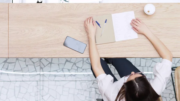 Estudiante repite el material antes de la lección. Joven morena sentada en la mesa con portátil — Foto de Stock