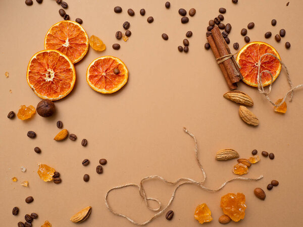 Citrus and spicy background with coffee beans and spices, warm ochre background