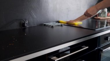 Ev işleri, mutfağı temizlemek. Siyah tezgahı sil ve kırıntıları pişir.,