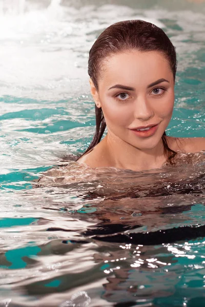 Mooie jonge vrouw zwemmen in het zwembad, portret. Aantrekkelijk brunette meisje — Stockfoto