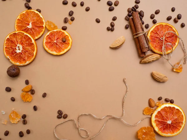 Zitrusfrüchte und würziger Hintergrund mit Kaffeebohnen und Gewürzen, warmer ockerfarbener Hintergrund — Stockfoto