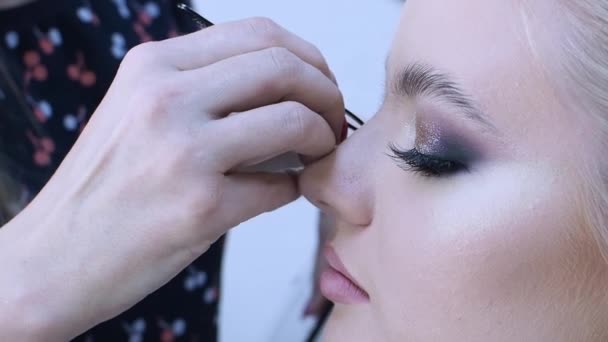 Eyelash extensions, make-up master lijmt trossen wimpers, een helder glamoureus beeld voor een feestje. — Stockvideo