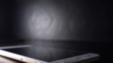 Kırık akıllı telefon ekranı, kırık ekranlı bir el telefonu kaldırıyor.