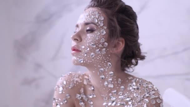 Maquillaje inusual y arte de la cara con diamantes de imitación brillantes en la piel . — Vídeos de Stock