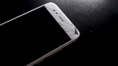 Kırık akıllı telefon ekranı, kırık ekranlı bir el telefonu kaldırıyor.