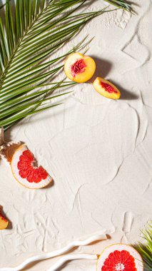 Sahil tatili. Bir palmiye yaprağı ve sulu meyveler beyaz ince kum üzerinde yatıyor. Masaüstü duvar kağıdı.