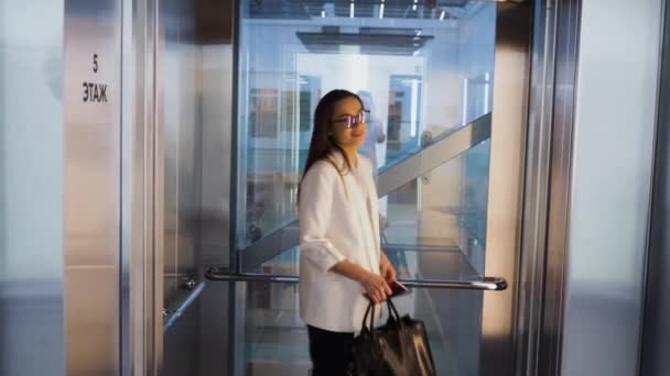 Charmante jonge zakenvrouw in de lift in het zakencentrum. Een jonge vrouw. — Stockvideo