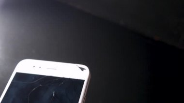 Kırık akıllı telefon ekranı, kırık ekranlı bir el telefonu kaldırıyor.