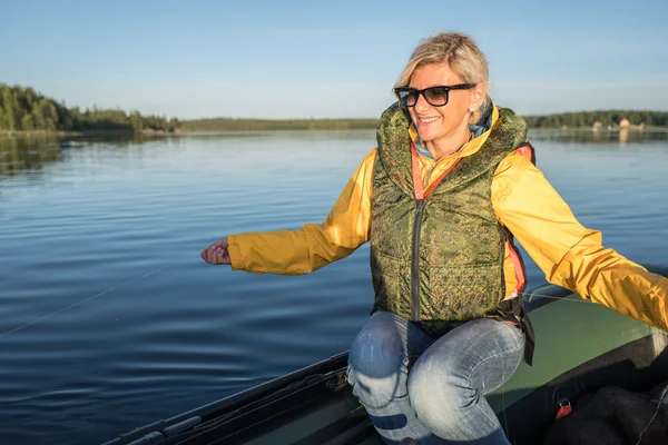 Blond meisje is op de boot met vislijn zitplaatsen in haar handen — Stockfoto