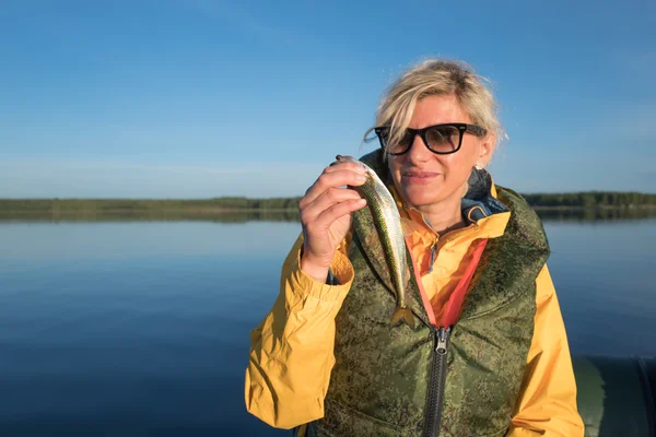 Blond meisje ving een smelt in de zee — Stockfoto