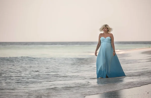 Felice donna incinta sta camminando sulla spiaggia delle Maldive — Foto Stock