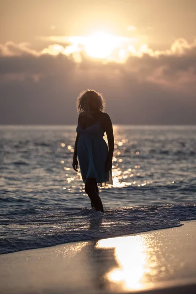 Menina está andando na praia das Maldivas durante o nascer do sol — Fotografia de Stock