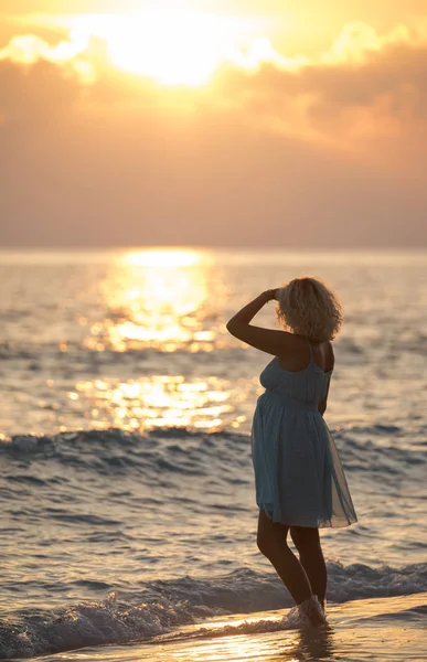 金发女郎是站在马尔代夫的海滩上，看日出 — 图库照片