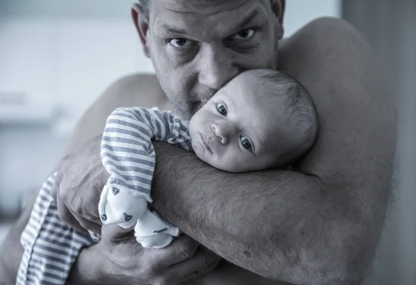 Brutal bonito pai segurando bebê menino filho enquanto olha para a câmera — Fotografia de Stock