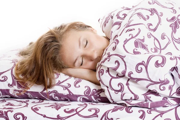 Mooie vrouw slapen en glimlacht in zijn slaap in bed — Stockfoto