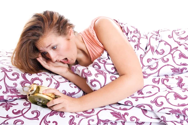 Vrouw in bed te realiseren dat ze heeft geslapen ondanks het hebben van een wekker. — Stockfoto